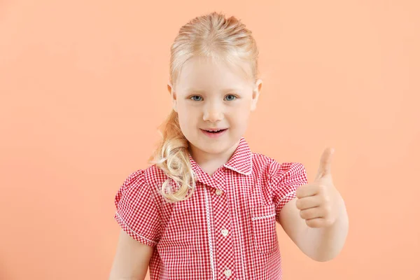 Πορτρέτο του αξιολάτρευτο μικρό κορίτσι δείχνοντας αντίχειρας-up χειρονομία στο χρώμα φόντο — Φωτογραφία Αρχείου