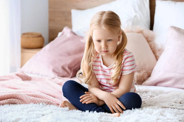 Niña triste sentada en la cama — Foto de Stock