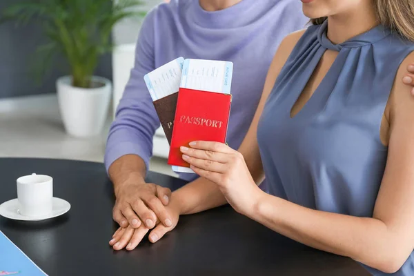 Young couple with passports and tickets in travel agency — Stock Photo, Image