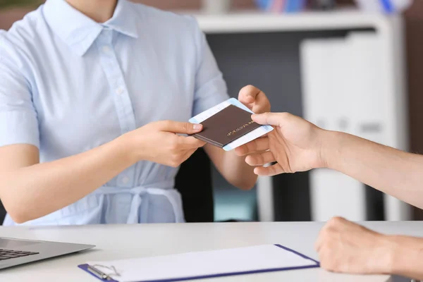 Female travel agent giving passport and ticket to man in office — Stock Photo, Image