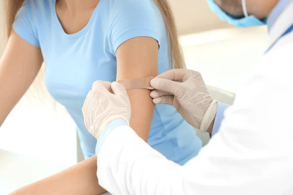 Doctor vaccinating young woman in clinic — Stock Photo, Image