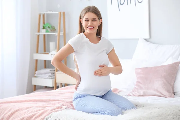 Hermosa mujer embarazada en el dormitorio — Foto de Stock