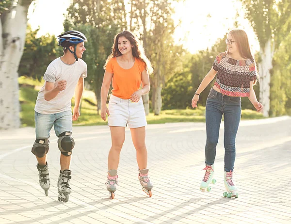 Teenagers on roller skates outdoors Stock Photo