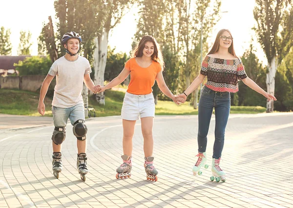 Teenagers on roller skates outdoors Stock Picture