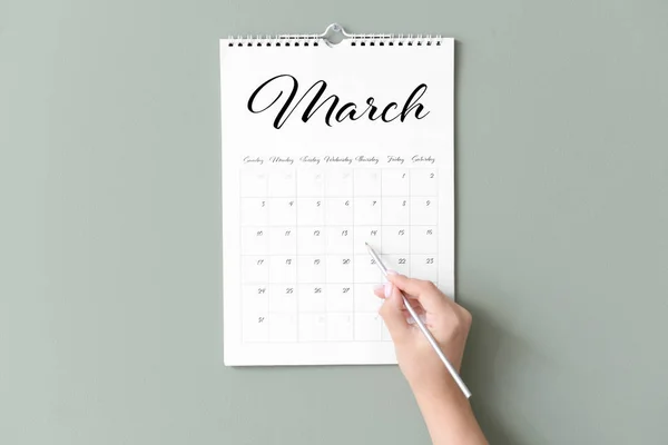 Woman marking date in calendar on color background — Stock Photo, Image