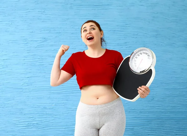 Happy overweight woman with scales on color background. Weight loss concept — Stock Photo, Image