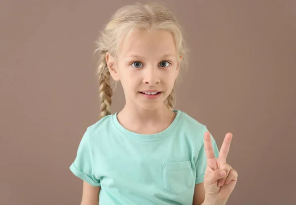 Malá hluchá dívka používající jazyk podepisování na pozadí barev — Stock fotografie