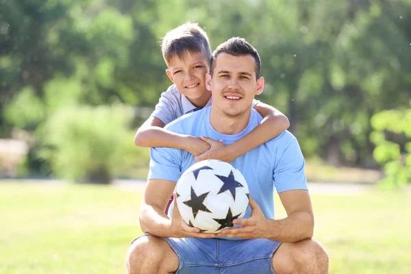 Bambino e suo padre con pallone da calcio all'aperto — Foto Stock