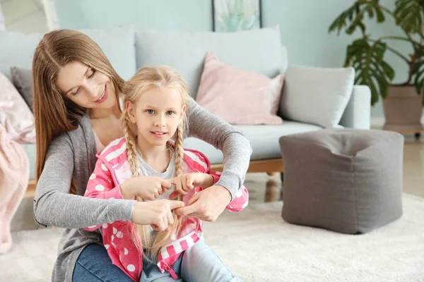 Little deaf mute girl and her mother using sign language at home