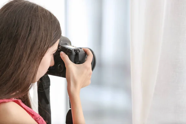 Молодая девушка с современной фотокамерой дома — стоковое фото