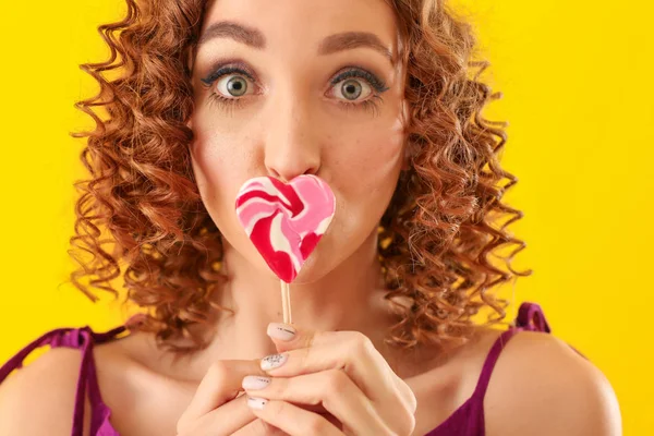 情感年轻女子与美味的棒棒糖在颜色背景 — 图库照片