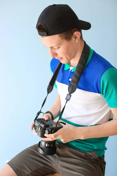 Nastoletni chłopiec z aparatem fotograficznym na kolorowym tle — Zdjęcie stockowe
