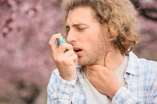 Człowiek z inhalatorem o ataku astmy w dniu wiosny — Zdjęcie stockowe