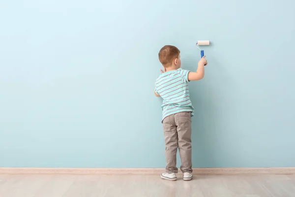 Lindo niño pintando pared en la habitación —  Fotos de Stock