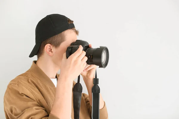 Nastoletni chłopiec z aparatem fotograficznym na jasnym tle — Zdjęcie stockowe