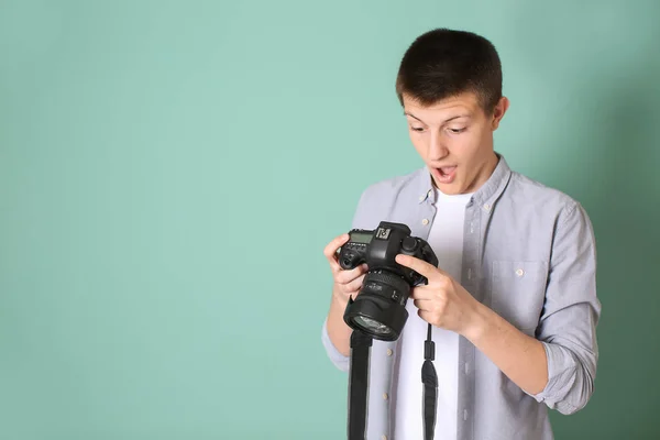 Meglepett tizenéves fiú fotókamera színes háttér — Stock Fotó