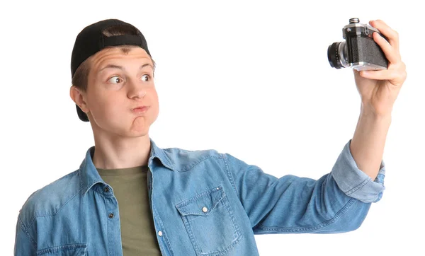 Мальчик-подросток с фотокамерой делает селфи на белом фоне — стоковое фото