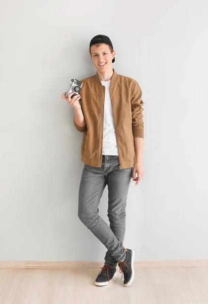 Έφηβο αγόρι με φωτογραφική μηχανή κοντά στο φως τοίχο — Φωτογραφία Αρχείου