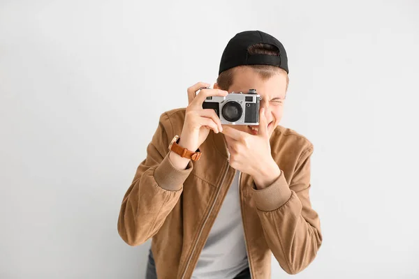 Menino adolescente com câmera de foto no fundo claro — Fotografia de Stock