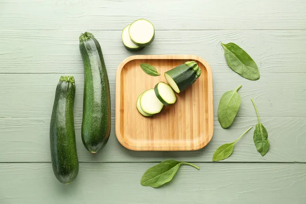 Fresh zucchini squashes with plate on wooden background — Stock Photo, Image