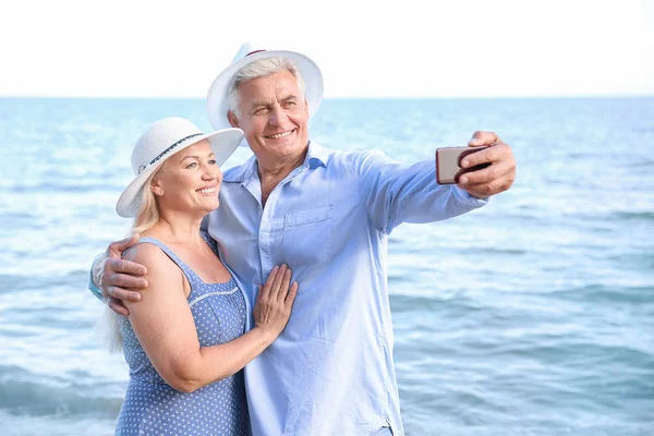 Feliz maduro casal tomando selfie no mar resort — Fotografia de Stock