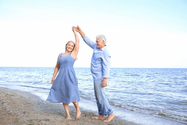 Happy mature couple dancing at sea resort — Stock Photo, Image