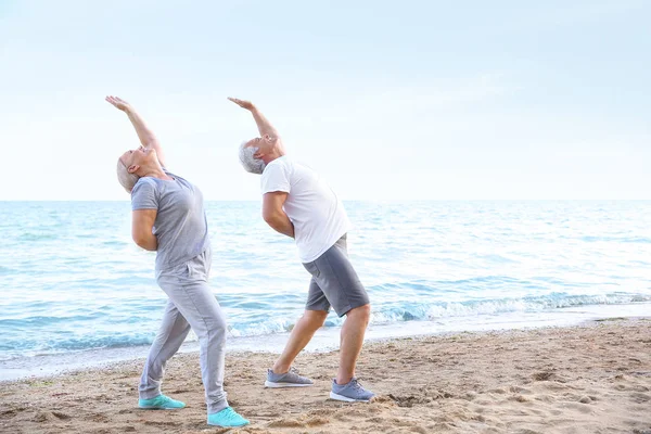 Olgun çift deniz Resort Yoga pratik — Stok fotoğraf