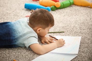 Evde çizim yapan şirin bir çocuk.