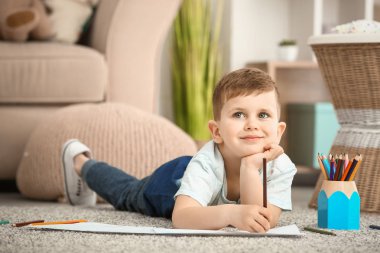 Evde çizim yapan şirin bir çocuk.