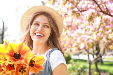 Bahar gününde parkta çiçek buket ile güzel genç kadın