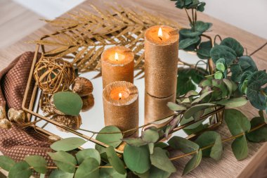 Masada yanan mumlar ve okaliptüs dalları ile tepsi