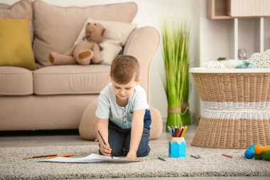 Evde çizim yapan şirin bir çocuk.