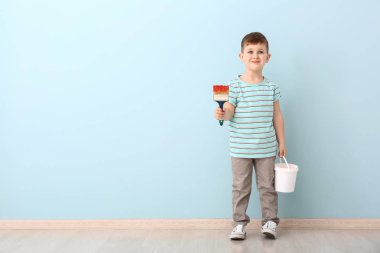 Fırça ve renkli duvara yakın boya kova ile sevimli küçük çocuk