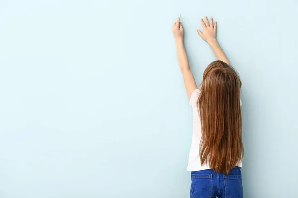 Klein meisje tekening op kleur muur — Stockfoto