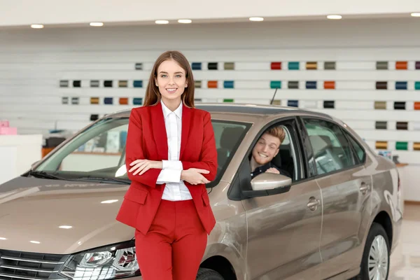 Saleswoman a vevő a modern autós bemutatóteremben — Stock Fotó
