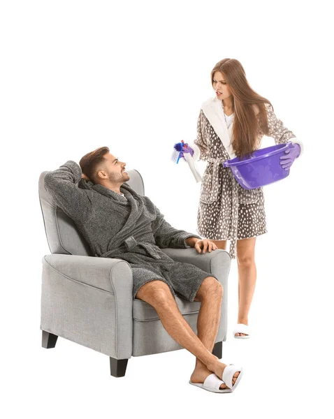 Indignant woman scolding her lazy husband against white background — Stock Photo, Image