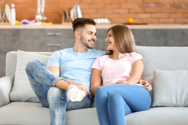 Feliz pareja joven descansando juntos en el sofá en casa — Foto de Stock