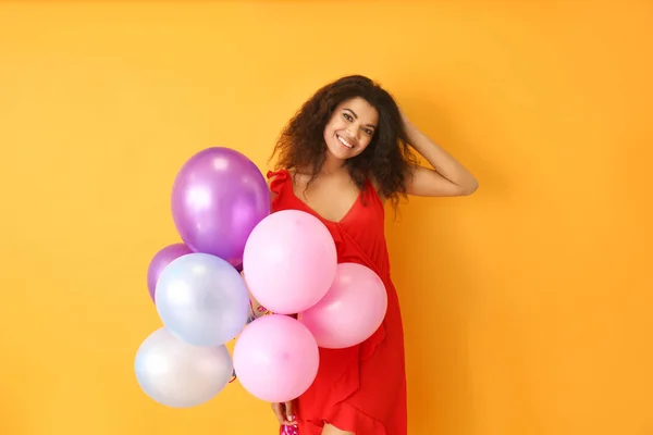 Retrato de mujer afroamericana feliz con globos de aire sobre fondo de color — Foto de Stock