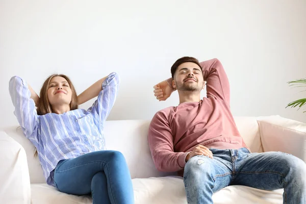 Gelukkig jong paar rusten samen op sofa thuis — Stockfoto