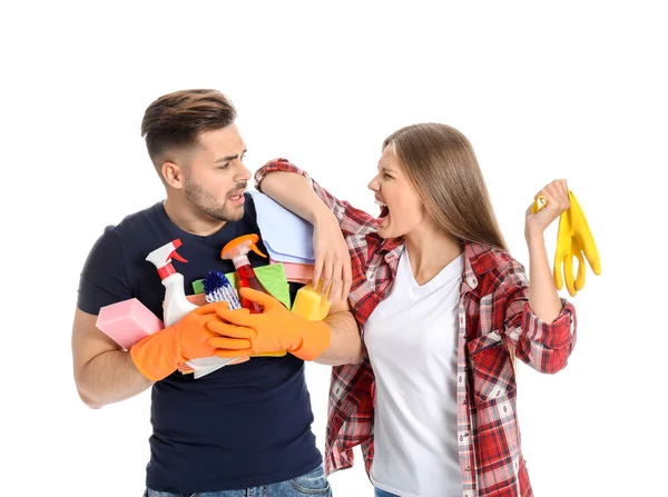 Esposa irritada repreendendo seu marido com suprimentos de limpeza no fundo branco — Fotografia de Stock