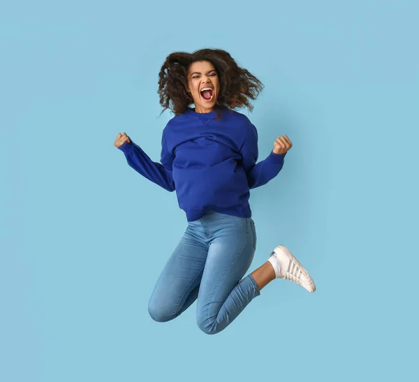 Jumping African-American woman on color background — Stock Photo, Image