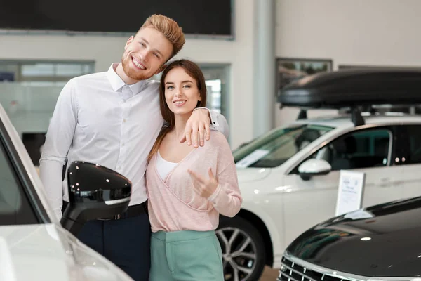 Happy couple choosing new car in salon — Stock Photo, Image