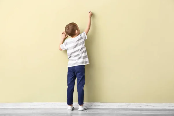 Little boy drawing on color wall — Stock Photo, Image