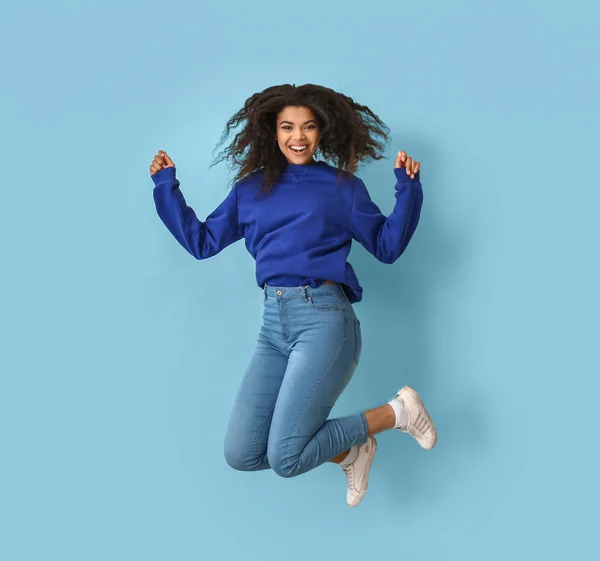 Jumping African-American woman on color background — Stock Photo, Image