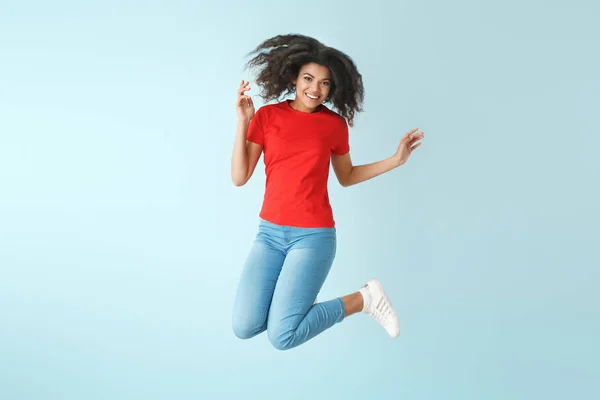 Salto donna afro-americana su sfondo di colore — Foto Stock