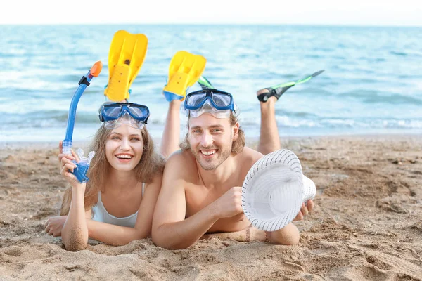 Happy young couple with snorkeling masks and paddles at sea resort — Stock Photo, Image