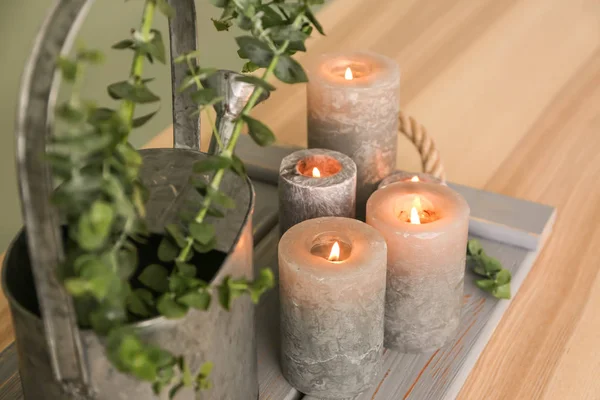 Bougies brûlantes et arrosoir avec branches d'eucalyptus sur la table — Photo