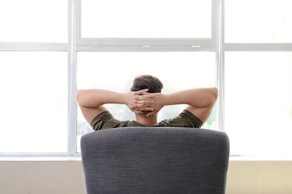 Handsome man resting in armchair at home — Stock Photo, Image