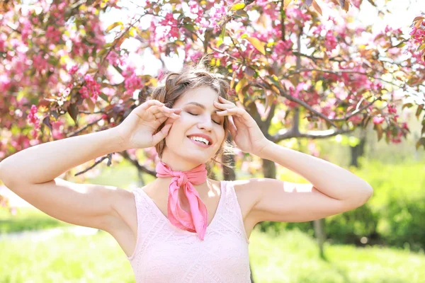 Bahar gününde çiçeklenme tree yakınındaki güzel genç kadın — Stok fotoğraf