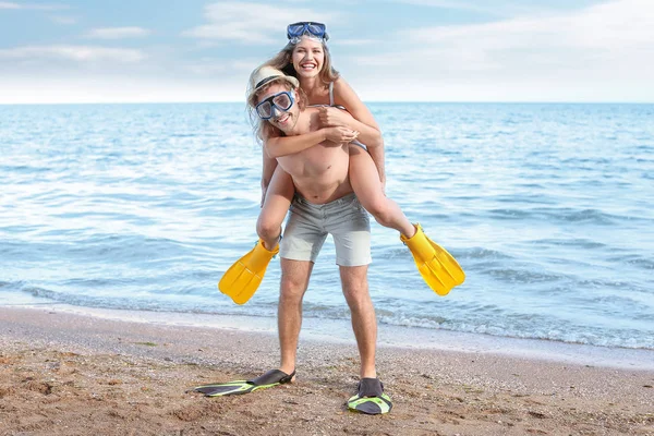 Happy young couple with snorkeling masks and paddles at sea resort — Stock Photo, Image
